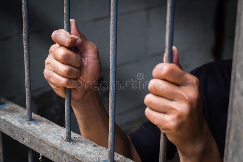 Mani dell'uomo dietro le barre della prigione