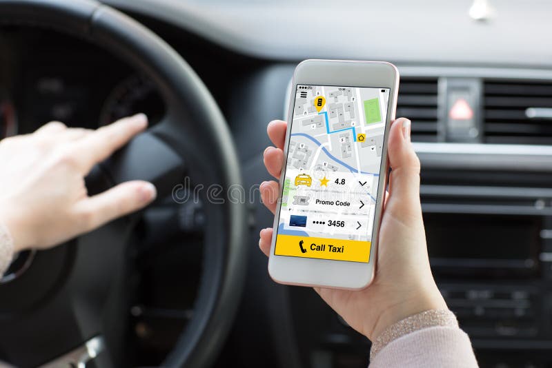 Mani della donna che tengono telefono con il taxi di chiamata di app nell'automobile