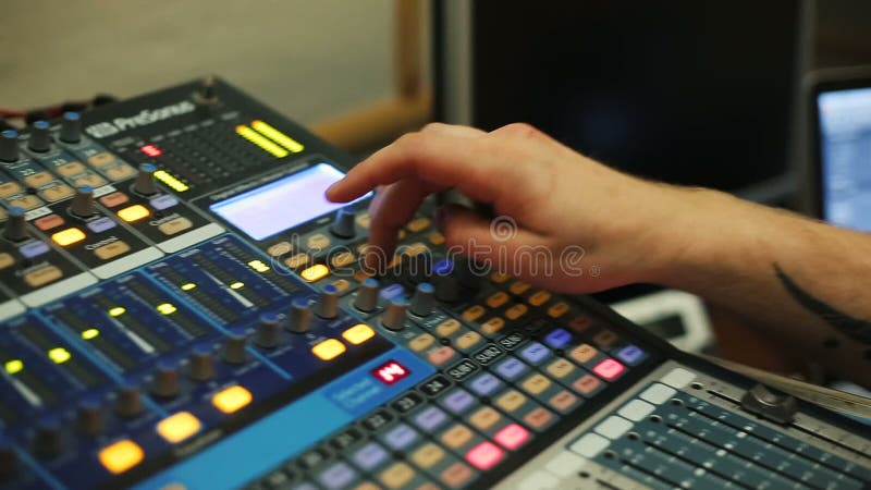 Mani di audio ingegnere che lavorano ad una console analogica professionale, musica mescolantesi