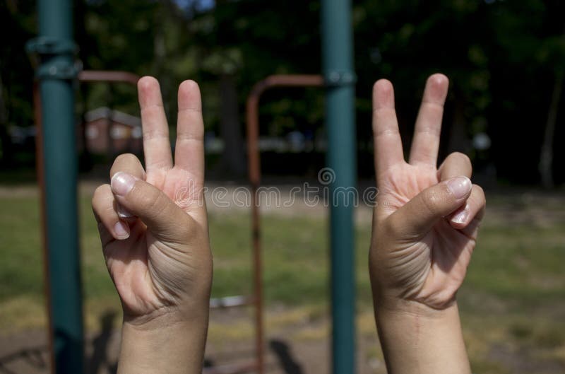 Childs hands making peace signs with both hands. Childs hands making peace signs with both hands