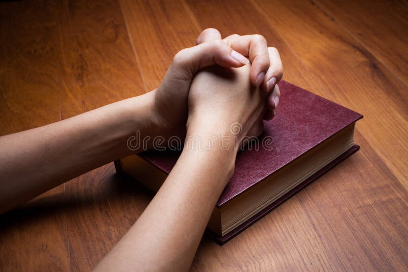 Mani di una donna su una bibbia immagini stock libere da diritti Mani di una donna su una bibbia immagini stock libere da diritti