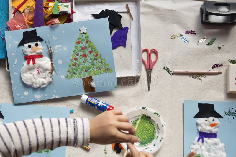 Mani di una ragazza di 10 anni che fa un mestiere di Natale fotografia stock Mani di una ragazza di 10 anni che fa un mestiere di Natale fotografia stock