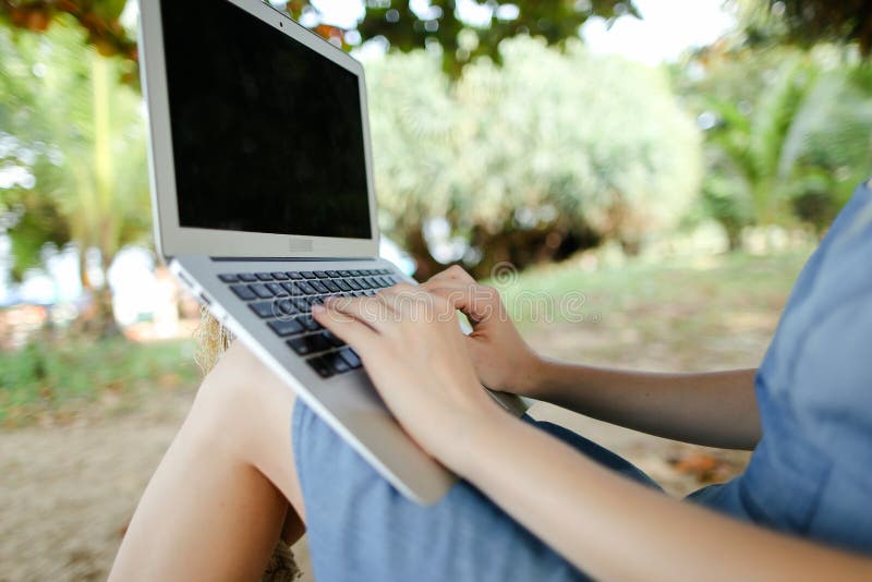 Mani femminili con laptop con sabbia sullo sfondo nero. immagine stock libera da diritti