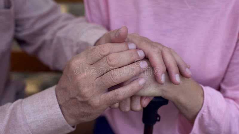 Mani femminili invecchiate della copertura maschio, cure domiciliari di professione d'infermiera, supporto della famiglia, assist immagini stock libere da diritti Mani femminili invecchiate della copertura maschio, cure domiciliari di professione d'infermiera, supporto della famiglia, assist immagini stock libere da diritti