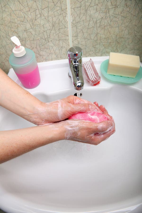 Mani insaponate del lavaggio della donna in bagno