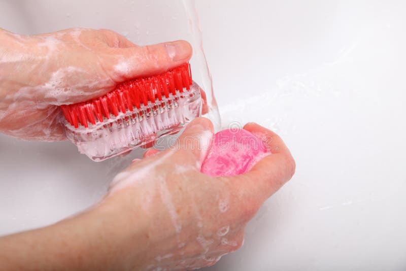 Mani insaponate della lavata della donna in stanza da bagno