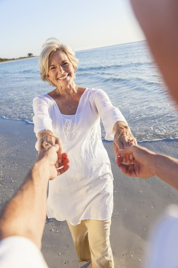 Mani senior felici della tenuta di Dancing delle coppie su una spiaggia tropicale fotografie stock Mani senior felici della tenuta di Dancing delle coppie su una spiaggia tropicale fotografie stock