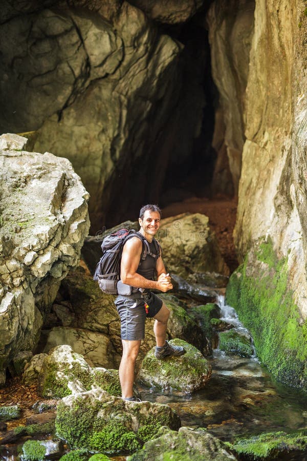 Mani turistiche di lavaggio dell'uomo in un fiume della montagna fotografia stock Mani turistiche di lavaggio dell'uomo in un fiume della montagna fotografia stock