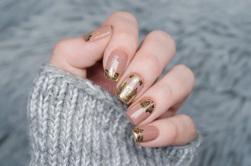 Manicura Beige Nude Con Un Patrón De Encaje Dorado Sobre Fondo Gris Foto de  archivo - Imagen de manera, humano: 167400456