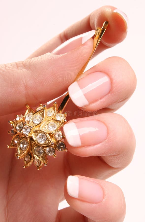 Womanâ€™s hand with French manicure and glitter hairpin. Womanâ€™s hand with French manicure and glitter hairpin