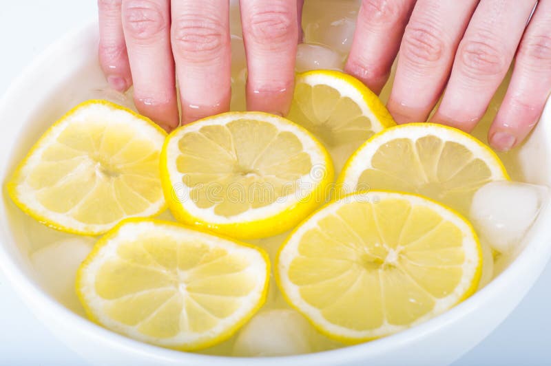 Manicura Jugo de limón, cosméticos naturales Las uñas de impregnación de la mujer en agua del jugo de limón fotografía de archivo Manicura Jugo de limón, cosméticos naturales Las uñas de impregnación de la mujer en agua del jugo de limón fotografía de archivo
