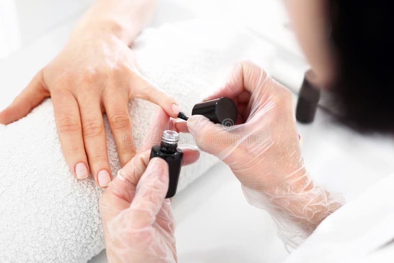 Nail Painting Process. a Manicure Master Hand Holds Red Painted
