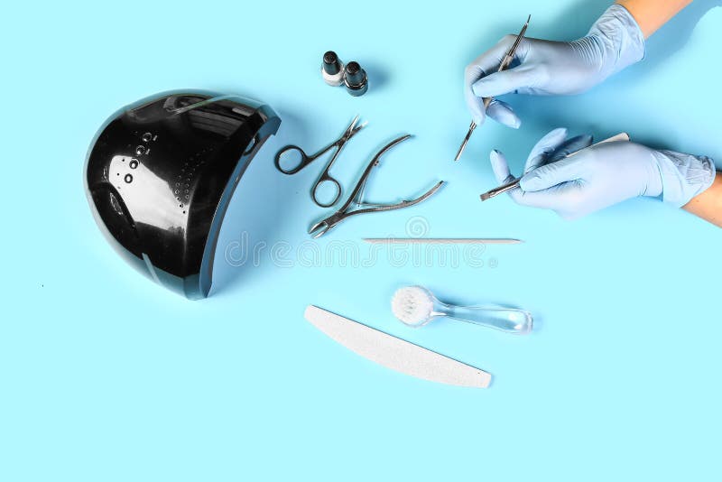 Manicure Tool in the Hands of the Master. Set of Manicure Accessories on Blue Background Top