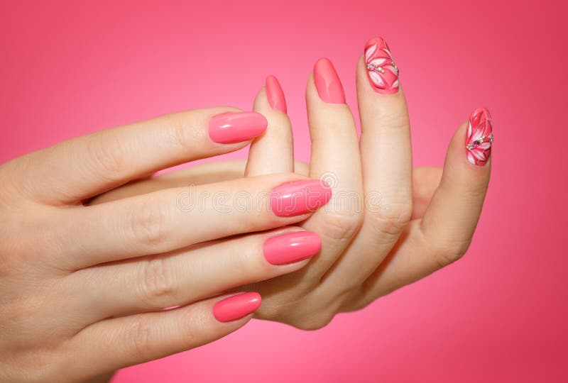 Manicured woman`s nails with pink nailart with flowers.