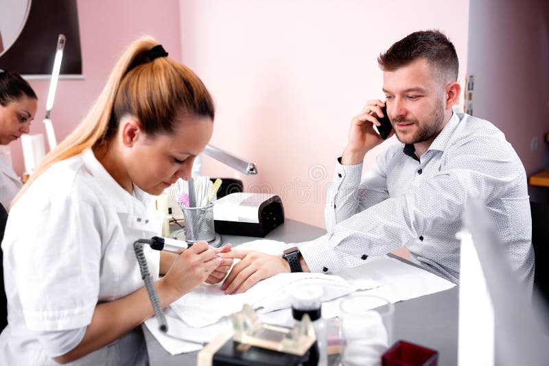 Manicurist rounding the shape of nail with electric nail machine royalty free stock photos Manicurist rounding the shape of nail with electric nail machine royalty free stock photos
