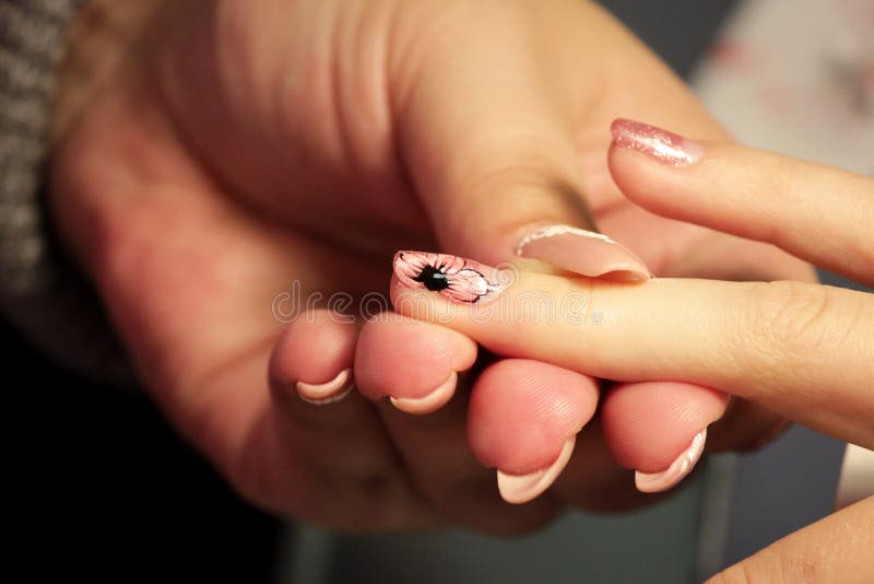 Manicurist at the training courses of manicure applies color gel shell. color pink gold. formation of wells with a thin