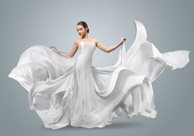Manierportret van een mooie vrouw in een golvende witte kleding Lichte stoffenvliegen in de wind royalty-vrije stock foto Manierportret van een mooie vrouw in een golvende witte kleding Lichte stoffenvliegen in de wind royalty-vrije stock foto