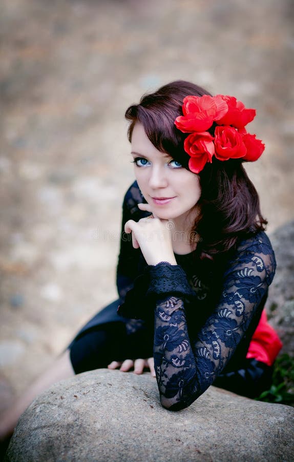 Manierportret van een vrouw in zwart kant met rode bloemen op steenachtergrond royalty-vrije stock foto's Manierportret van een vrouw in zwart kant met rode bloemen op steenachtergrond royalty-vrije stock foto's