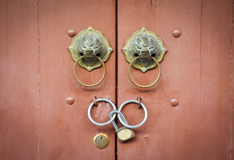 Maniglia della porta cinese e lucchetto del leone sul fondo di legno marrone vicino della porta fotografia stock libera da diritti