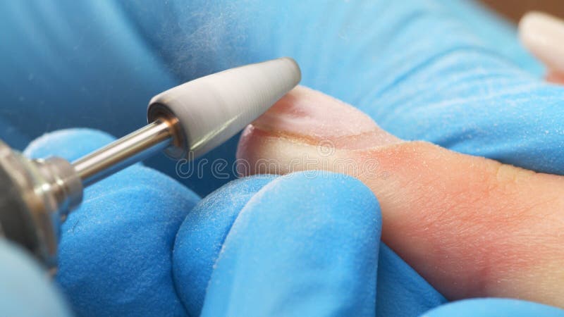 Manicurist in process of removing gel polish or acrylic from nails using  manicure machine. Process of hardware manicure in the salon.  Nail manicure process in a beauty salon. Nail beauty salon. Manicurist in process of removing gel polish or acrylic from nails using  manicure machine. Process of hardware manicure in the salon.  Nail manicure process in a beauty salon. Nail beauty salon