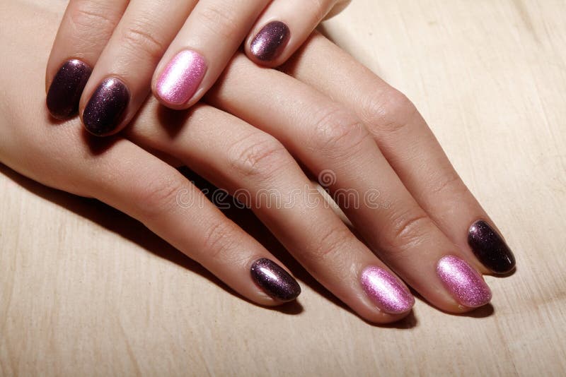 Bright pink and black nail polish wit sparkles. Manicured nails with shiny nail polish. Manicure with gel nailpolish. Fashion art manicure with shiny acrylic lacquer. Bright pink and black nail polish wit sparkles. Manicured nails with shiny nail polish. Manicure with gel nailpolish. Fashion art manicure with shiny acrylic lacquer