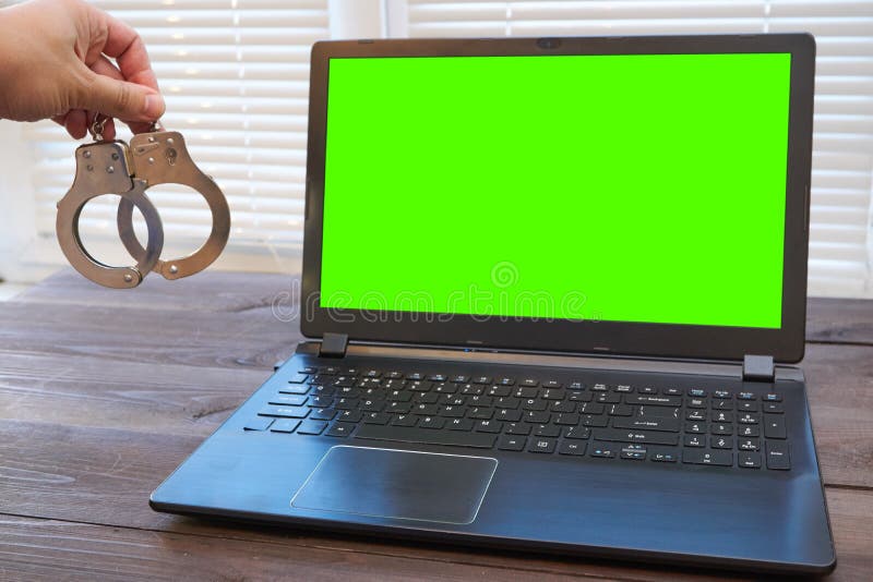 Maninnehavet handfängslar nära bärbara datorn arkivfoto Maninnehavet handfängslar nära bärbara datorn arkivfoto