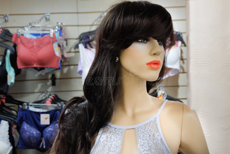 Maniquí femenino en una peluca en la tienda en el fondo de la ropa interior imagen de archivo libre de regalías Maniquí femenino en una peluca en la tienda en el fondo de la ropa interior imagen de archivo libre de regalías