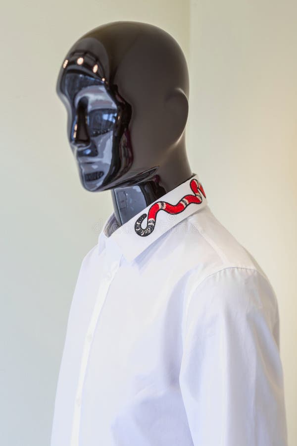 Maniquí masculino vestido en una camisa blanca con bordado en el cuello en un fondo beige ligero imágenes de archivo libres de regalías Maniquí masculino vestido en una camisa blanca con bordado en el cuello en un fondo beige ligero imágenes de archivo libres de regalías