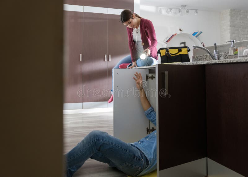 Manitas Husband y esposa que repara el fregadero de cocina imágenes de archivo libres de regalías Manitas Husband y esposa que repara el fregadero de cocina imágenes de archivo libres de regalías