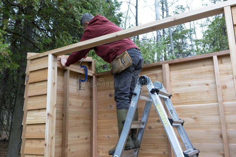 Manitas que construye a Cedar Storage Shed fotografía de archivo Manitas que construye a Cedar Storage Shed fotografía de archivo