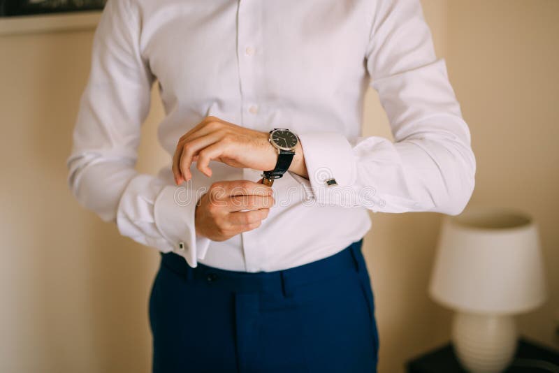 Manknappmanschettknappen på franska örfilar upp den lyxiga vita skjortan för muffar royaltyfri fotografi Manknappmanschettknappen på franska örfilar upp den lyxiga vita skjortan för muffar royaltyfri fotografi