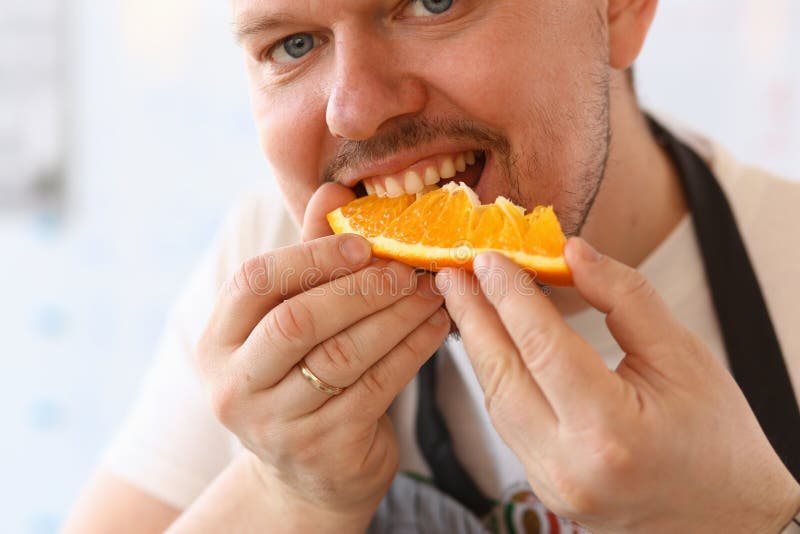 Mankock Eating Juice Orange Kitchen Portrait arkivfoton Mankock Eating Juice Orange Kitchen Portrait arkivfoton