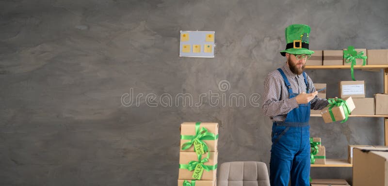 Manlig butikssäljare i leprechaun som äger småföretag som har smartphone med hjälp av mobil appskanning royaltyfri fotografi