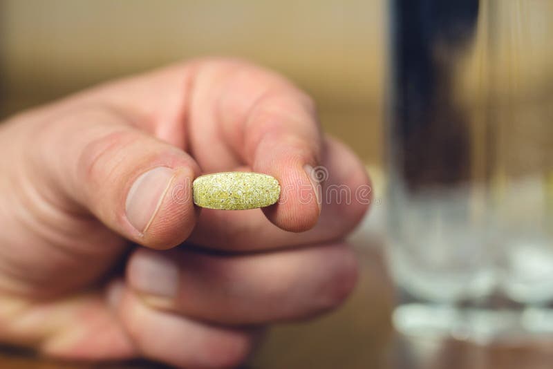 Manlig handinnehav och show av vitamin- eller läkarundersökningpreventivpilleren, närbild fotografering för bildbyråer Manlig handinnehav och show av vitamin- eller läkarundersökningpreventivpilleren, närbild fotografering för bildbyråer