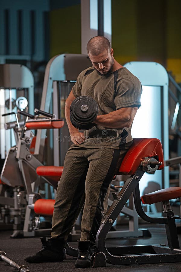 Manlig idrottare som lyfter en provdocka på ett gym under styrkeutbildning arkivfoton