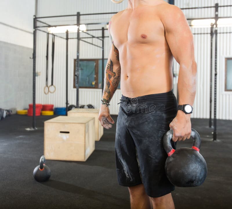 Manlig idrottsman nen Carrying Kettlebell royaltyfri bild
