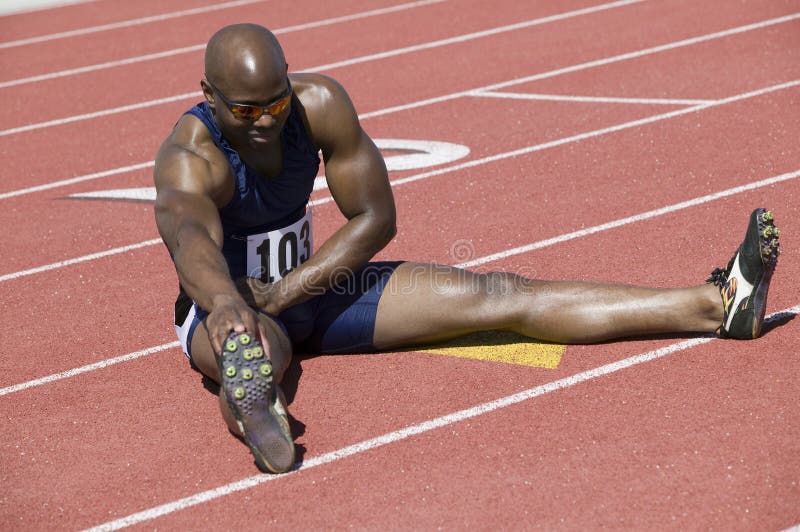Manlig idrottsman nen Stretching On Racetrack arkivfoton