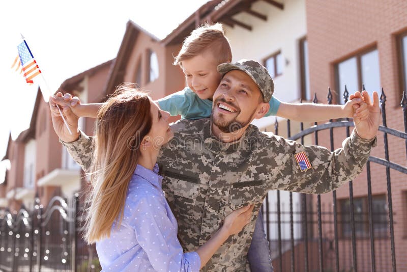 Manlig soldat som utomhus återförenas med hans familj Militärtjänst royaltyfri bild Manlig soldat som utomhus återförenas med hans familj Militärtjänst royaltyfri bild