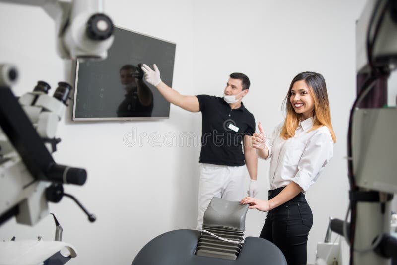 Manlig tandläkare som visar tand- röntgenstrålebild på datorbildskärm i en tand- klinik dentistry arkivbilder Manlig tandläkare som visar tand- röntgenstrålebild på datorbildskärm i en tand- klinik dentistry arkivbilder
