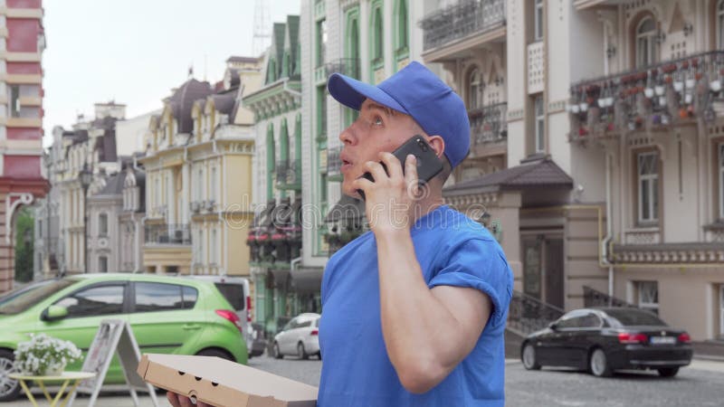 Manliga budfirmor som levererar pizza i staden ringer är klient på telefonen lager videofilmer