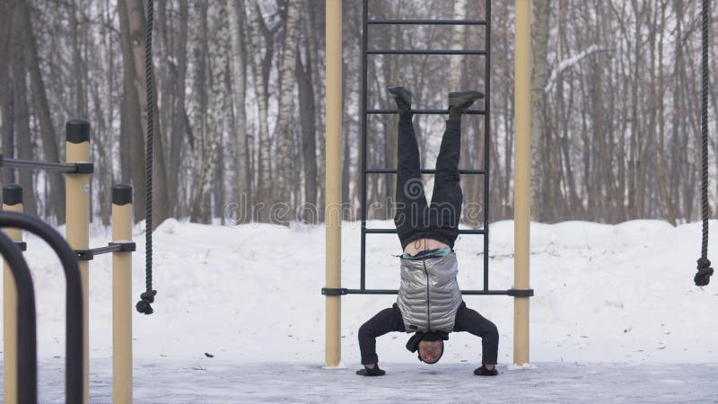 Mann, den Training drückt, ups Übung mit den Beinen, die oben auf WinterSportplatz anheben stockbilder Mann, den Training drückt, ups Übung mit den Beinen, die oben auf WinterSportplatz anheben stockbilder