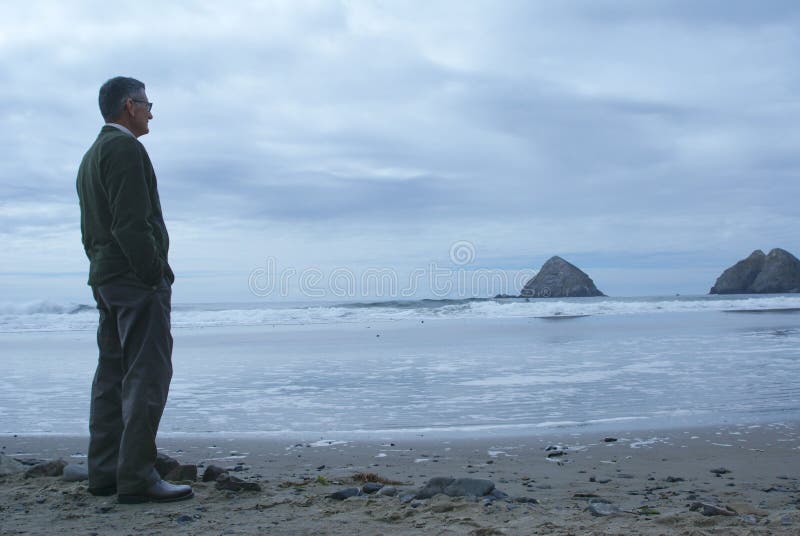Mann, der alleine auf dem Strand steht