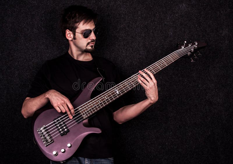 Mann, der auf Bass-Gitarre spielt lizenzfreies stockbild Mann, der auf Bass-Gitarre spielt lizenzfreies stockbild