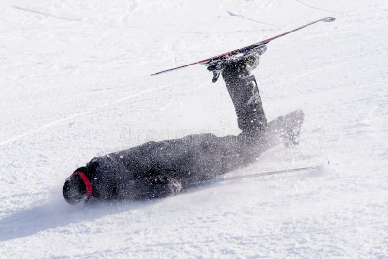 Young unskilled man falling on cold snow in ski crash at Sierrna Nevada resort in Spain in winter sport accident concept. Young unskilled man falling on cold snow in ski crash at Sierrna Nevada resort in Spain in winter sport accident concept