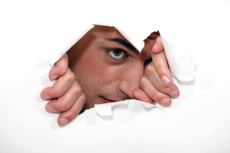 Man looking through hole in paper. Man looking through hole in paper