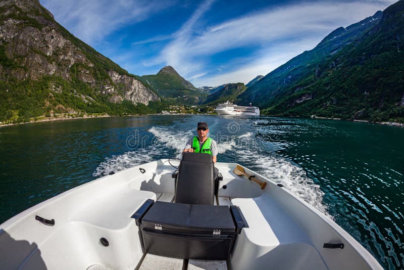 Mann, der ein Motorboot f?hrt Geiranger-Fjord, sch?ne Natur Norwegen Krasnodar Gegend, Katya lizenzfreies stockfoto Mann, der ein Motorboot f?hrt Geiranger-Fjord, sch?ne Natur Norwegen Krasnodar Gegend, Katya lizenzfreies stockfoto