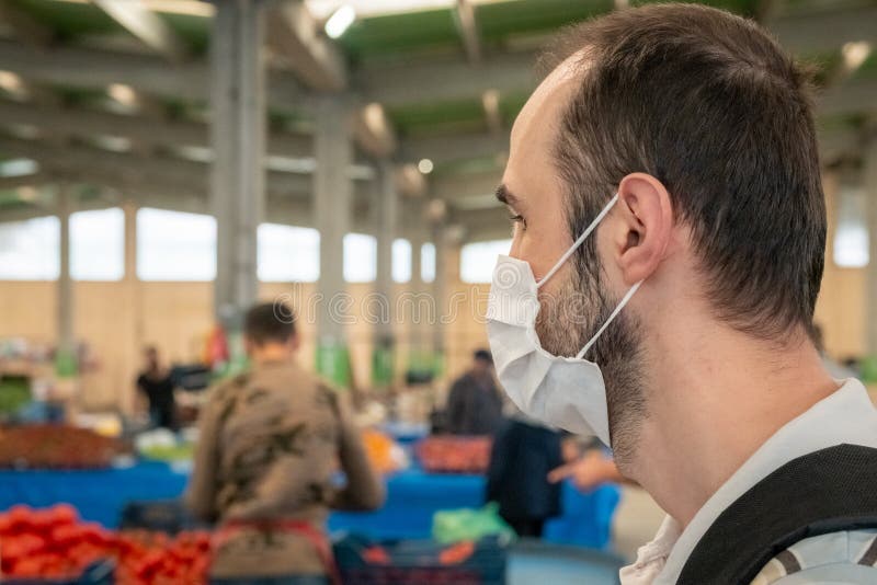 Mann, der eine medizinische Maske trägt, um während des covid19 Lebensmittelgeschäftbasareinkaufens zu verhindern stockbilder