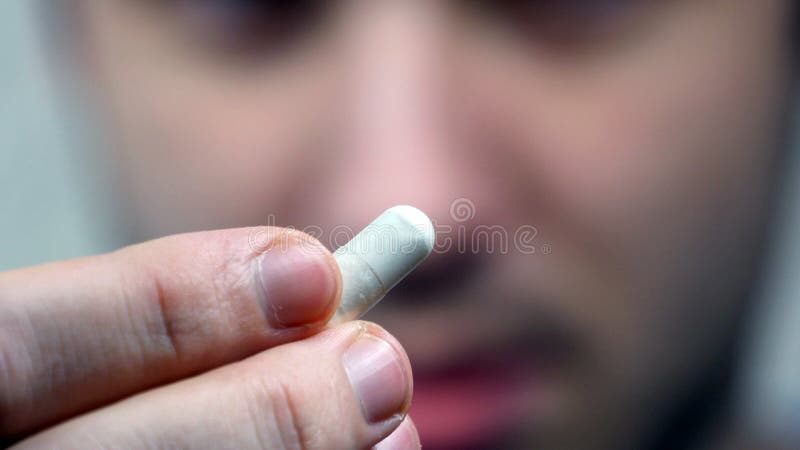 Mann, der eine Pille in seinen Mund einsetzt