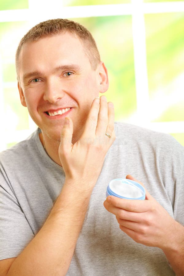 Mann, der Gesichtssahne aufträgt stockfotos Mann, der Gesichtssahne aufträgt stockfotos