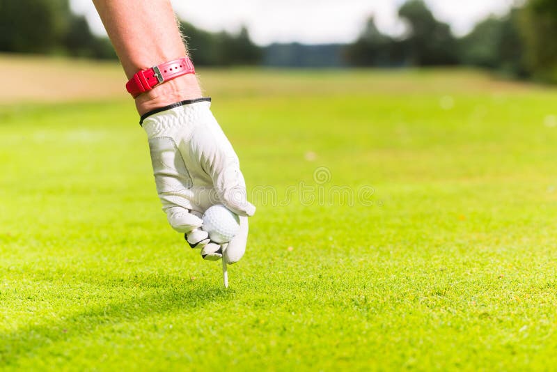 Mann, der Golfball auf T-Stück, Nahaufnahme setzt lizenzfreie stockbilder